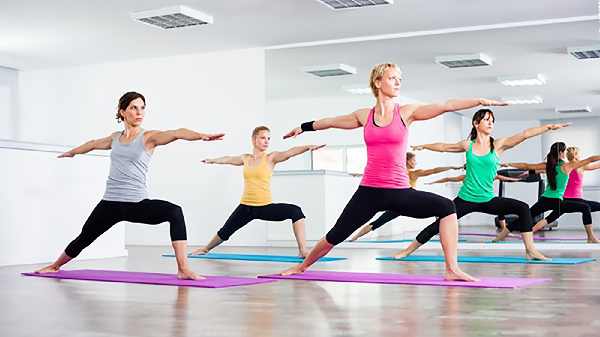 people in warrior pose in yoga class